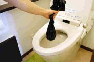 排便袋を便座からはずし、しっかりと結びます。